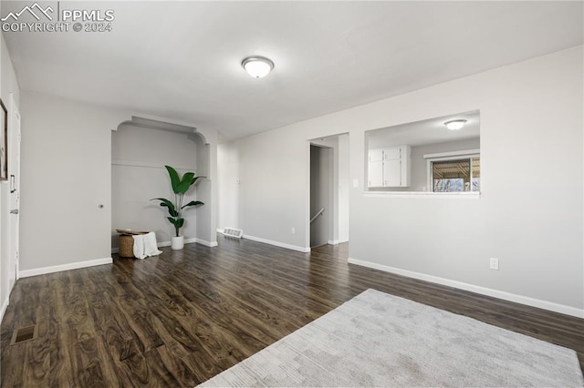 unfurnished room with dark hardwood / wood-style flooring