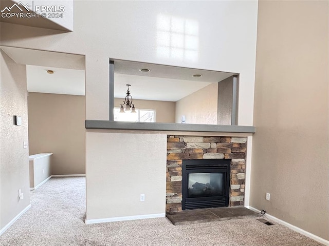 unfurnished living room featuring carpet floors, a fireplace, and an inviting chandelier