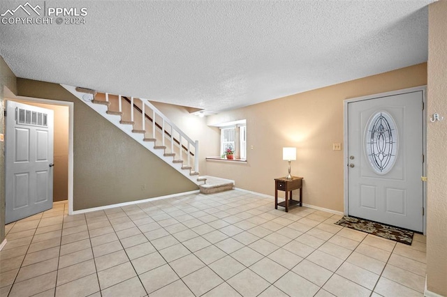 entryway with light tile patterned floors and a textured ceiling