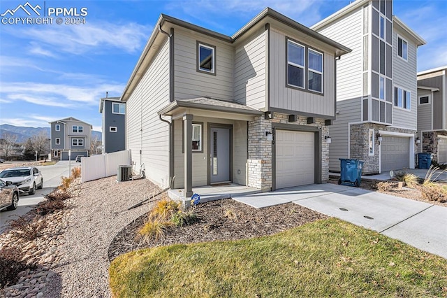 view of front of home featuring central AC unit and a garage