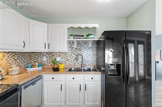 kitchen featuring dishwasher, sink, black fridge, backsplash, and white cabinets