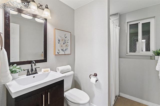 bathroom with tile patterned floors, vanity, and toilet