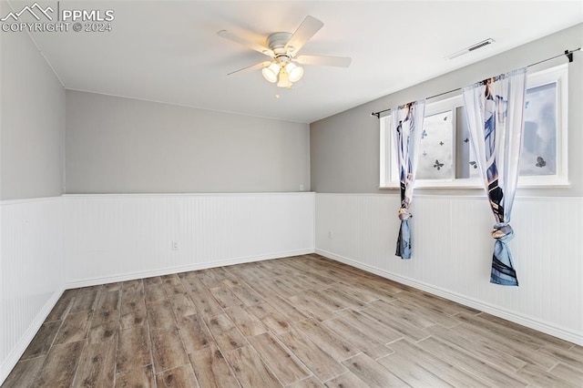 spare room with ceiling fan and light wood-type flooring