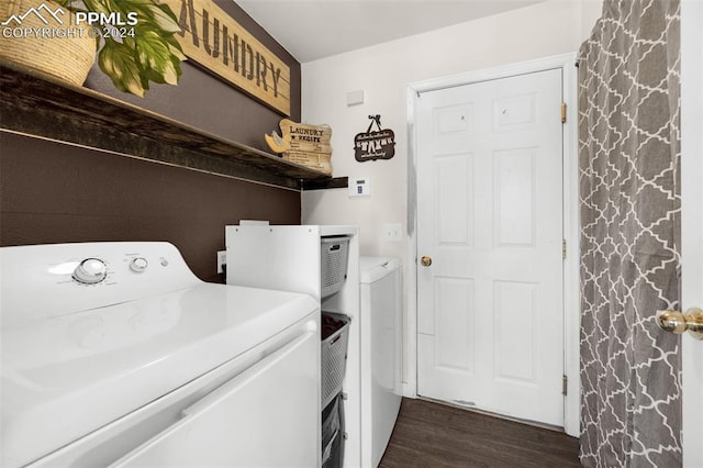 clothes washing area featuring dark wood-type flooring and washing machine and clothes dryer