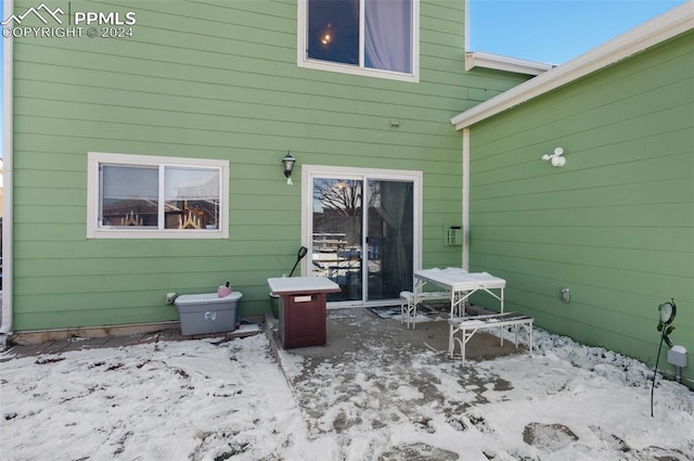 view of snow covered rear of property