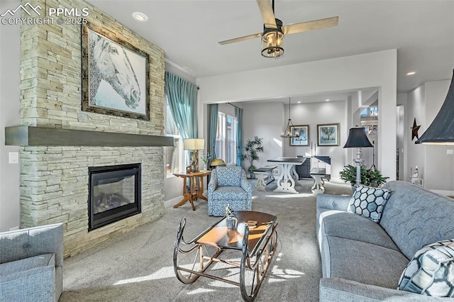 living room with ceiling fan, light colored carpet, and a stone fireplace