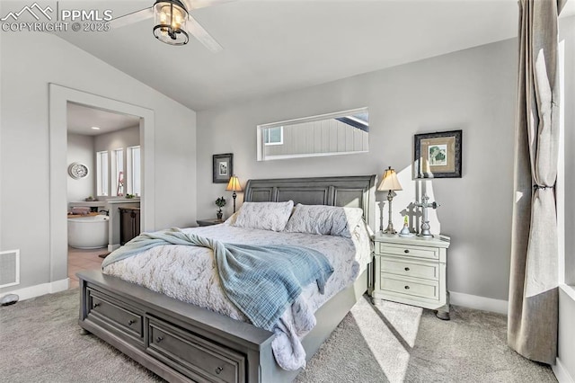 bedroom with ceiling fan, light colored carpet, ensuite bath, and vaulted ceiling