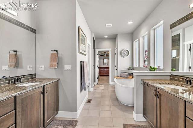 bathroom featuring vanity, a tub to relax in, and tile patterned flooring