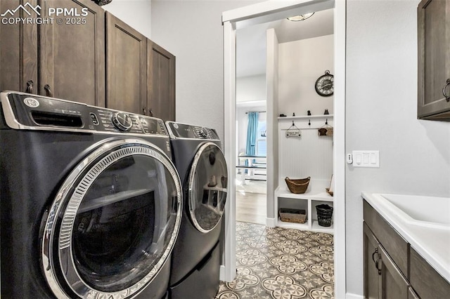 washroom featuring light tile patterned flooring, cabinets, and washing machine and clothes dryer