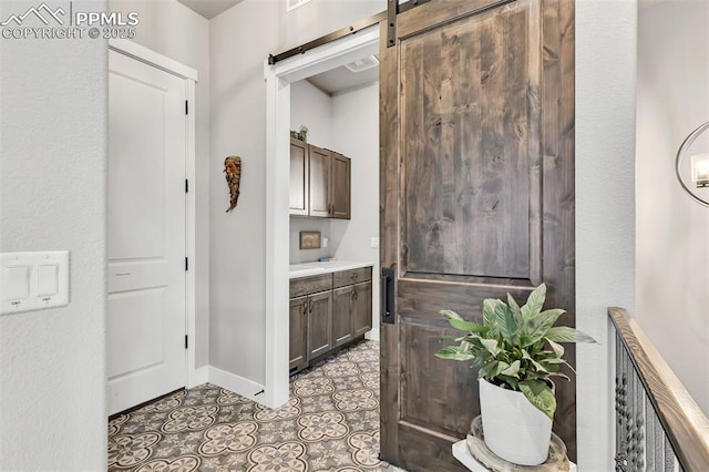 interior space featuring a barn door and light tile patterned flooring