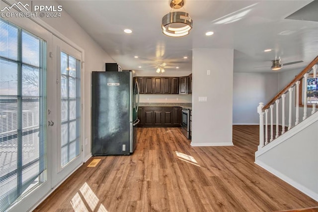 kitchen with light hardwood / wood-style flooring, dark brown cabinets, and appliances with stainless steel finishes