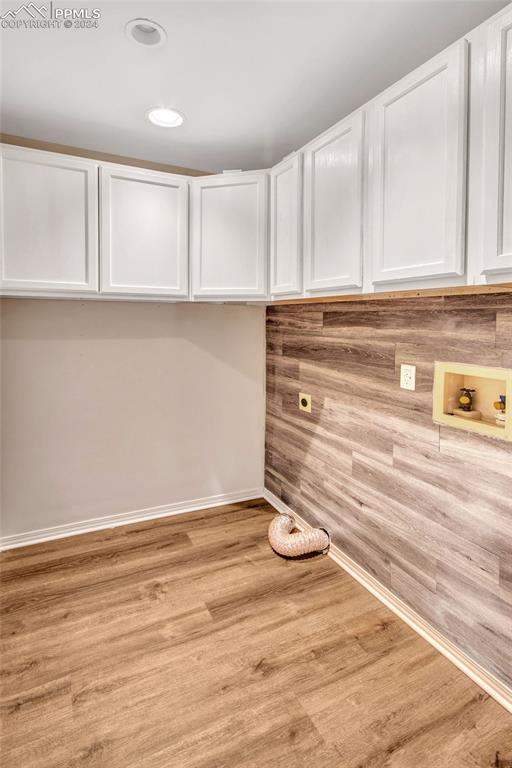 laundry room featuring light hardwood / wood-style floors, hookup for an electric dryer, cabinets, and washer hookup