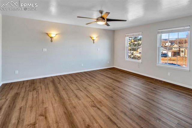 empty room with ceiling fan and hardwood / wood-style flooring