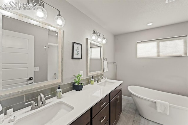 bathroom featuring decorative backsplash, vanity, and a tub