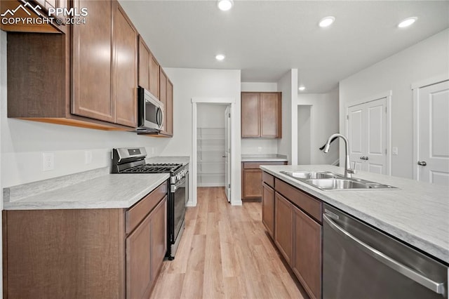 kitchen featuring stainless steel appliances, light hardwood / wood-style floors, and sink