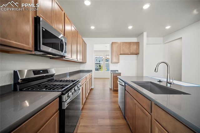 kitchen featuring appliances with stainless steel finishes, wood-type flooring, and sink