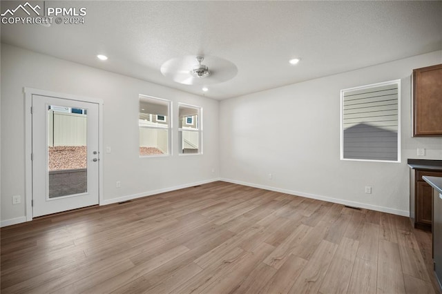 unfurnished living room with light hardwood / wood-style floors and ceiling fan