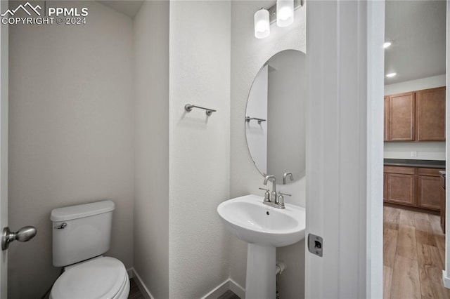 bathroom with hardwood / wood-style floors and toilet