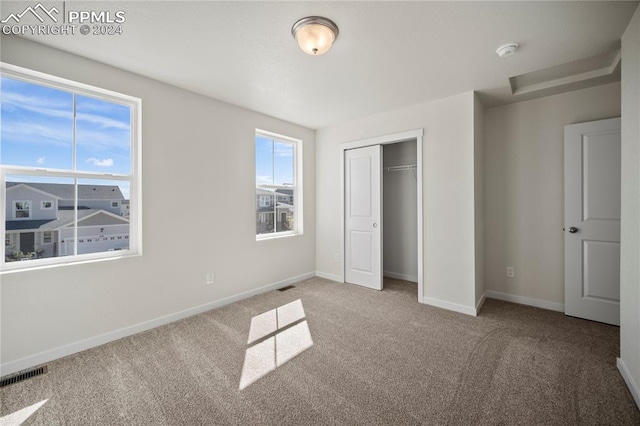 unfurnished bedroom featuring carpet floors and a closet