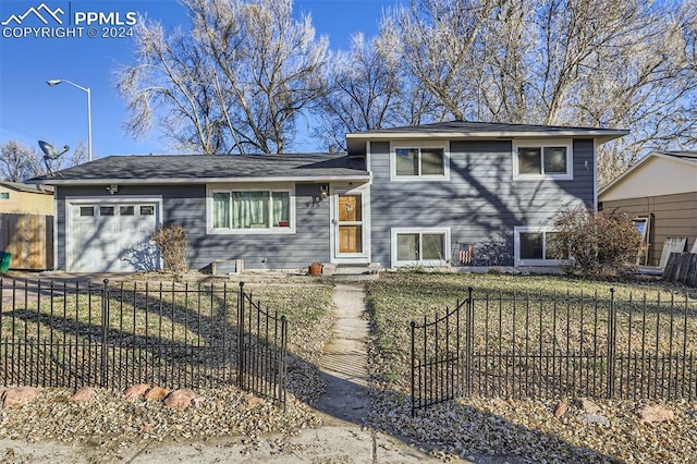 split level home with a garage and a front lawn