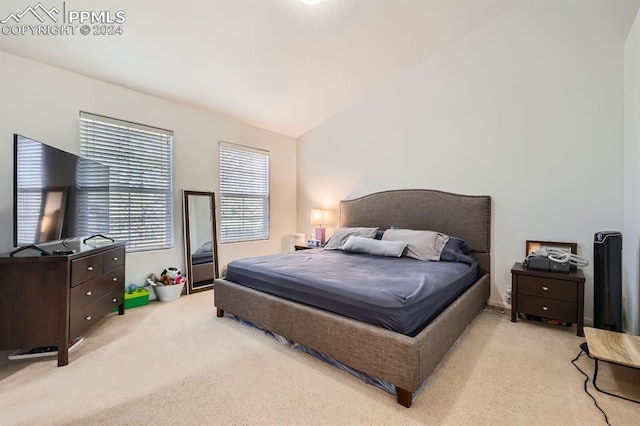 bedroom with light colored carpet and lofted ceiling