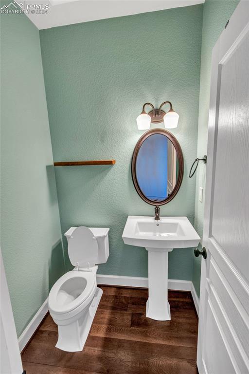 bathroom with hardwood / wood-style floors and toilet