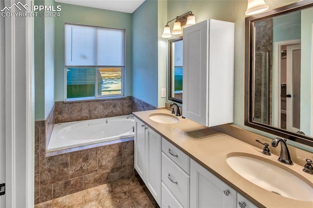 bathroom featuring vanity and tiled bath