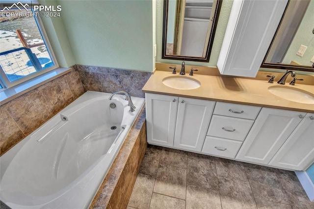 bathroom with vanity and tiled bath