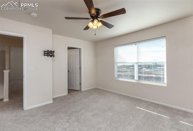 unfurnished bedroom with ceiling fan and light colored carpet