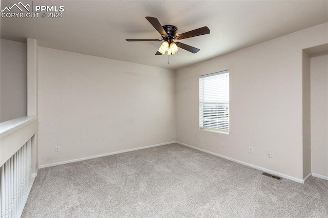 empty room featuring light colored carpet and ceiling fan