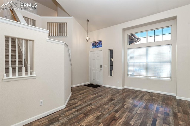 entrance foyer with dark hardwood / wood-style floors and high vaulted ceiling