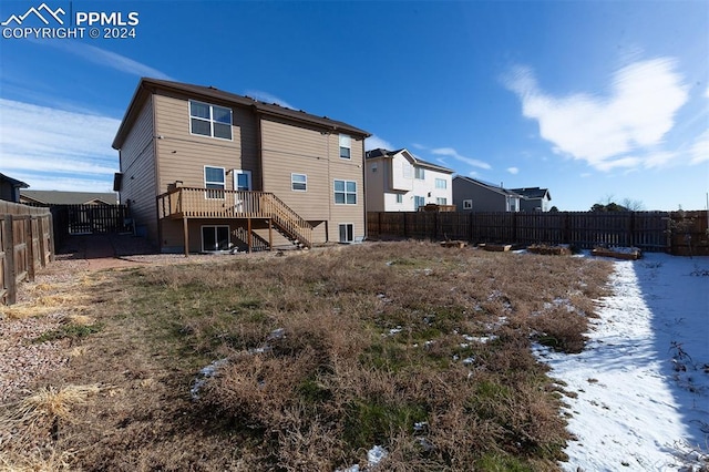 snow covered back of property featuring a deck and cooling unit