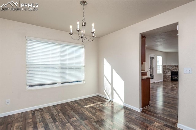 unfurnished room with dark wood-type flooring and an inviting chandelier