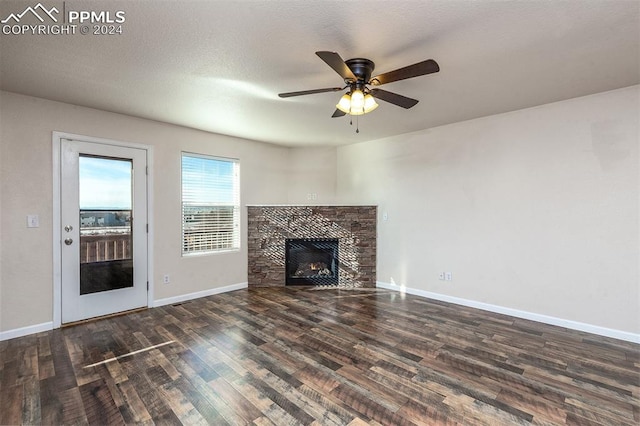 unfurnished living room featuring a textured ceiling, dark hardwood / wood-style floors, ceiling fan, and a fireplace