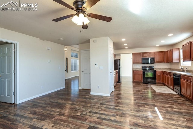 kitchen featuring lofted ceiling, dark wood-type flooring, black appliances, sink, and ceiling fan