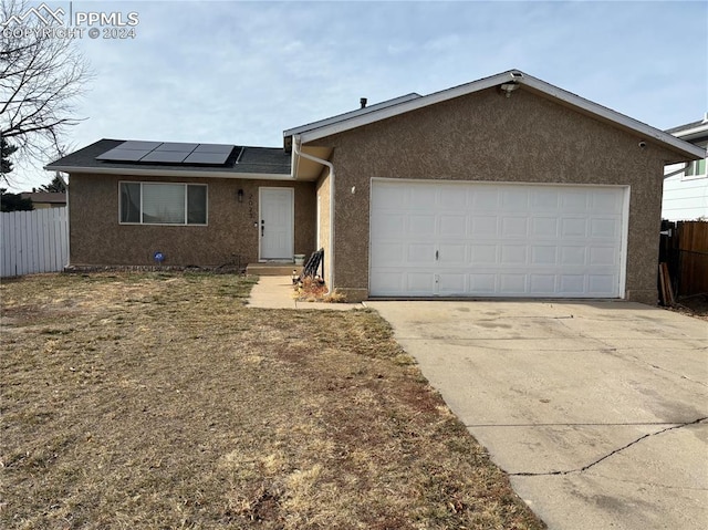 ranch-style home with solar panels and a garage