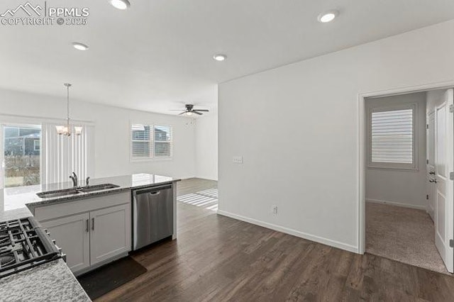 kitchen featuring stainless steel dishwasher, decorative light fixtures, dark hardwood / wood-style flooring, ceiling fan with notable chandelier, and sink