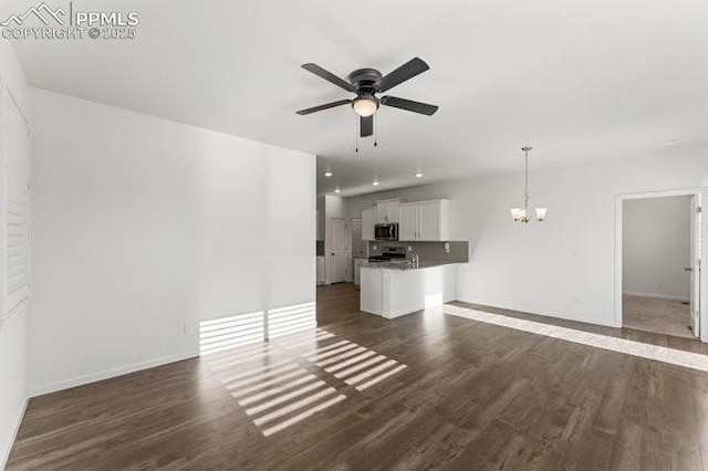 unfurnished living room with dark hardwood / wood-style floors and ceiling fan with notable chandelier