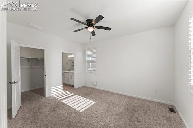 unfurnished bedroom featuring light carpet, ceiling fan, a closet, and connected bathroom