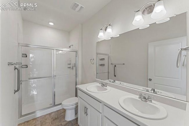 bathroom with an enclosed shower, vanity, and toilet