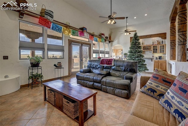 tiled living room with plenty of natural light, ceiling fan, and french doors