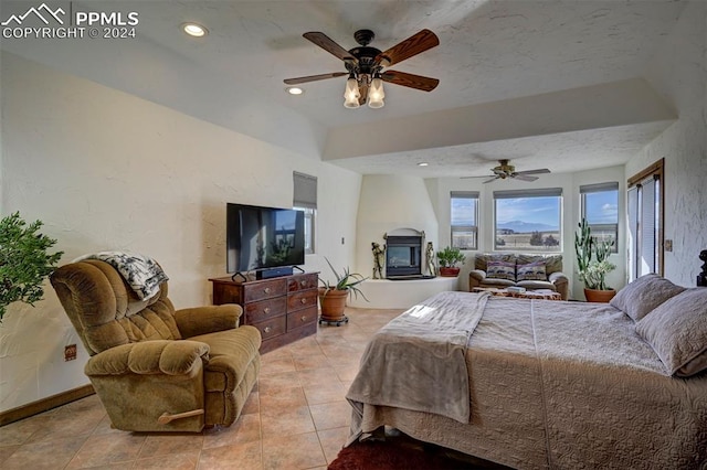 tiled bedroom with ceiling fan and a textured ceiling