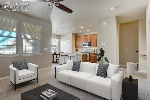 living room featuring light carpet and ceiling fan