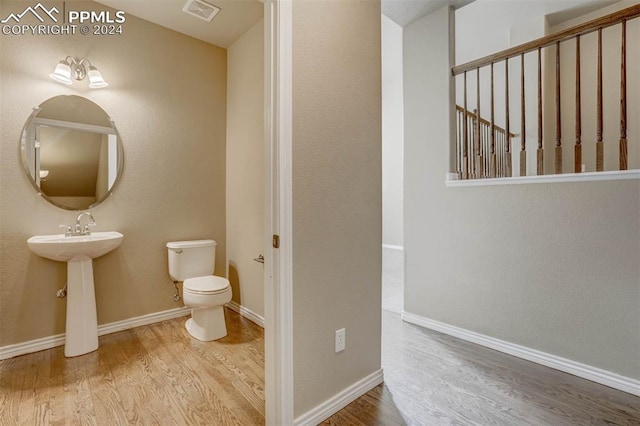 bathroom with hardwood / wood-style flooring and toilet