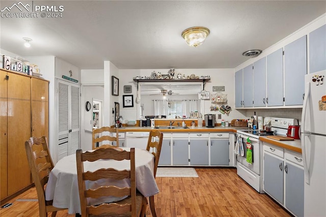 kitchen featuring butcher block counters, sink, light hardwood / wood-style flooring, white appliances, and decorative backsplash