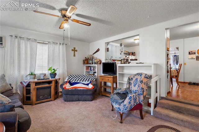 carpeted living room with ceiling fan and a textured ceiling