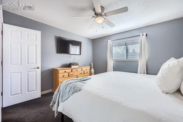 bedroom with ceiling fan, a textured ceiling, and dark colored carpet