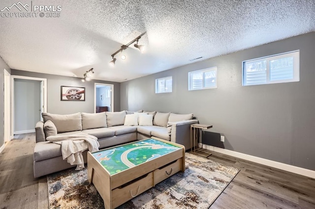 living room with hardwood / wood-style flooring, track lighting, and a textured ceiling