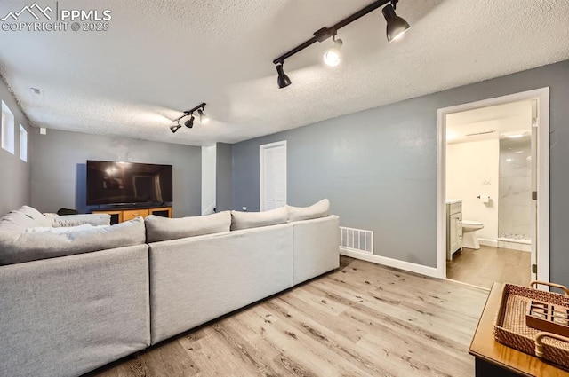 living room featuring wood-type flooring and a textured ceiling