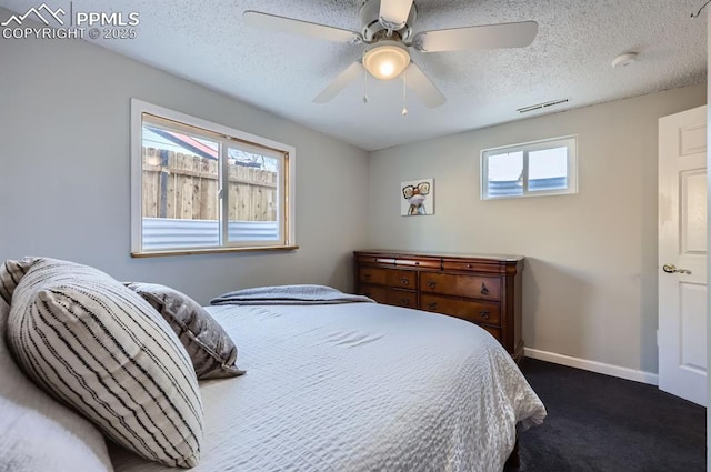 carpeted bedroom featuring ceiling fan and a textured ceiling